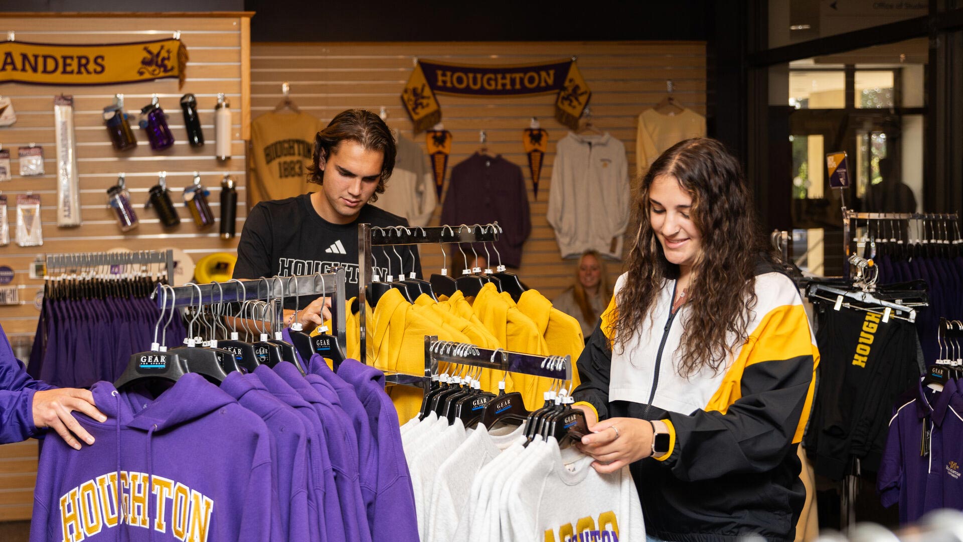 Two Houghton students looking through Highlander gear at the Highlander Shop.