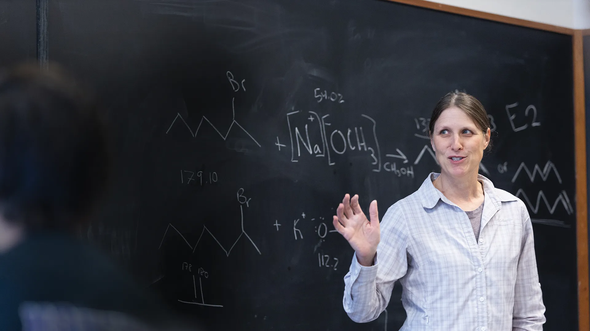 Houghton chemistry professor Dr. Karen Torraca teaching by blackboard.