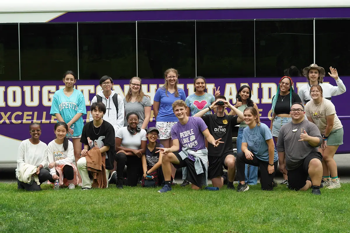 Houghton Interconnect students posing for picture in front of bus.