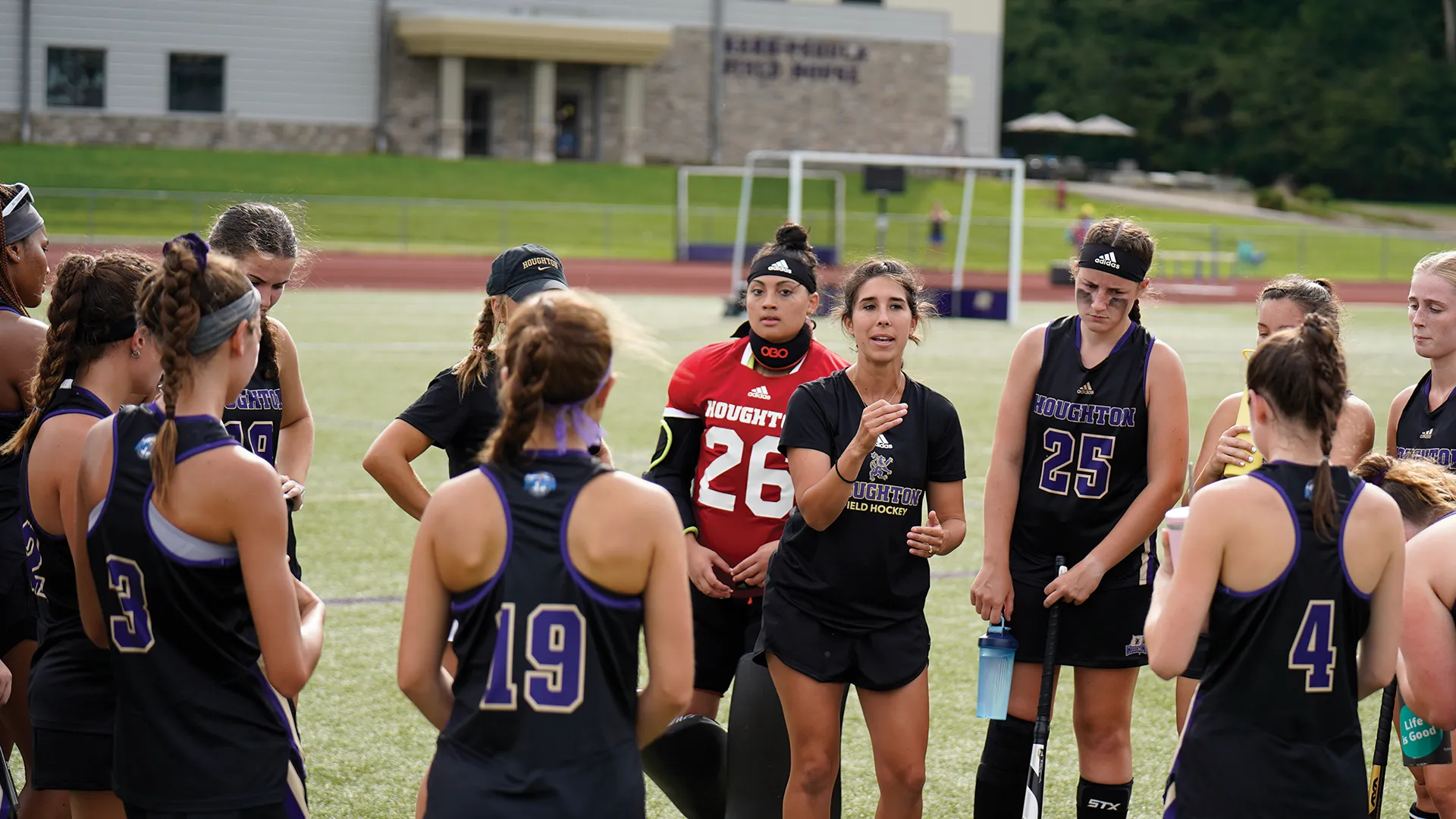 Houghton athletic coach Hannah Ogden coaching the field with the field hockey team.