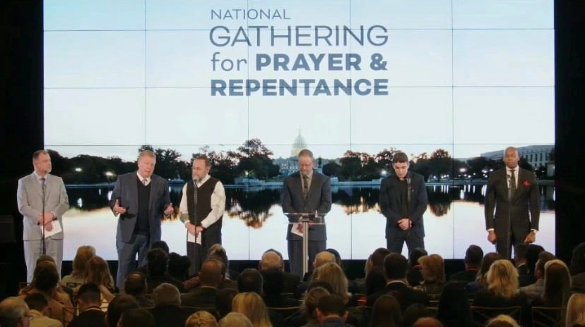 Six individuals standing on stage during the National Gathering for Prayer and Repentance in Washington D.C.