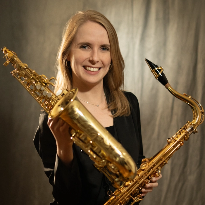 Houghton music faculty member Anne Kunkle holding saxophones.