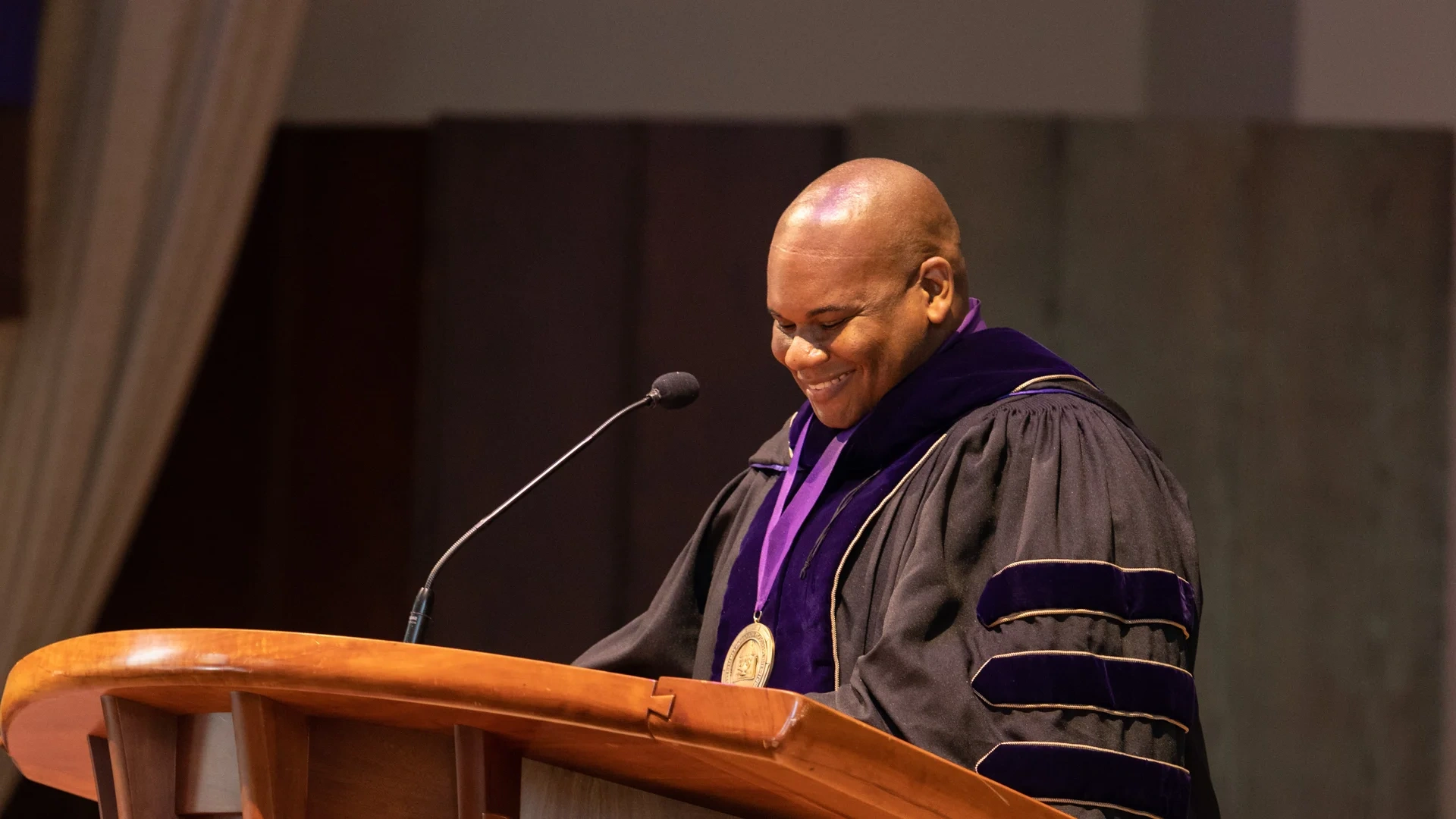 Houghton president, Wayne Lewis standing at behind lectern at commencement address.