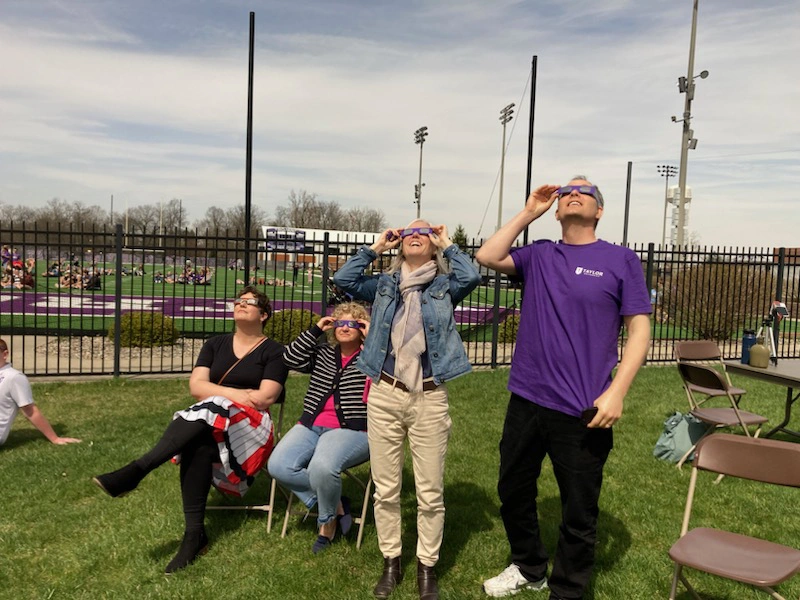 Houghton professor Katrina Koehler with Houghton alumni viewing the eclipse at Taylor University.