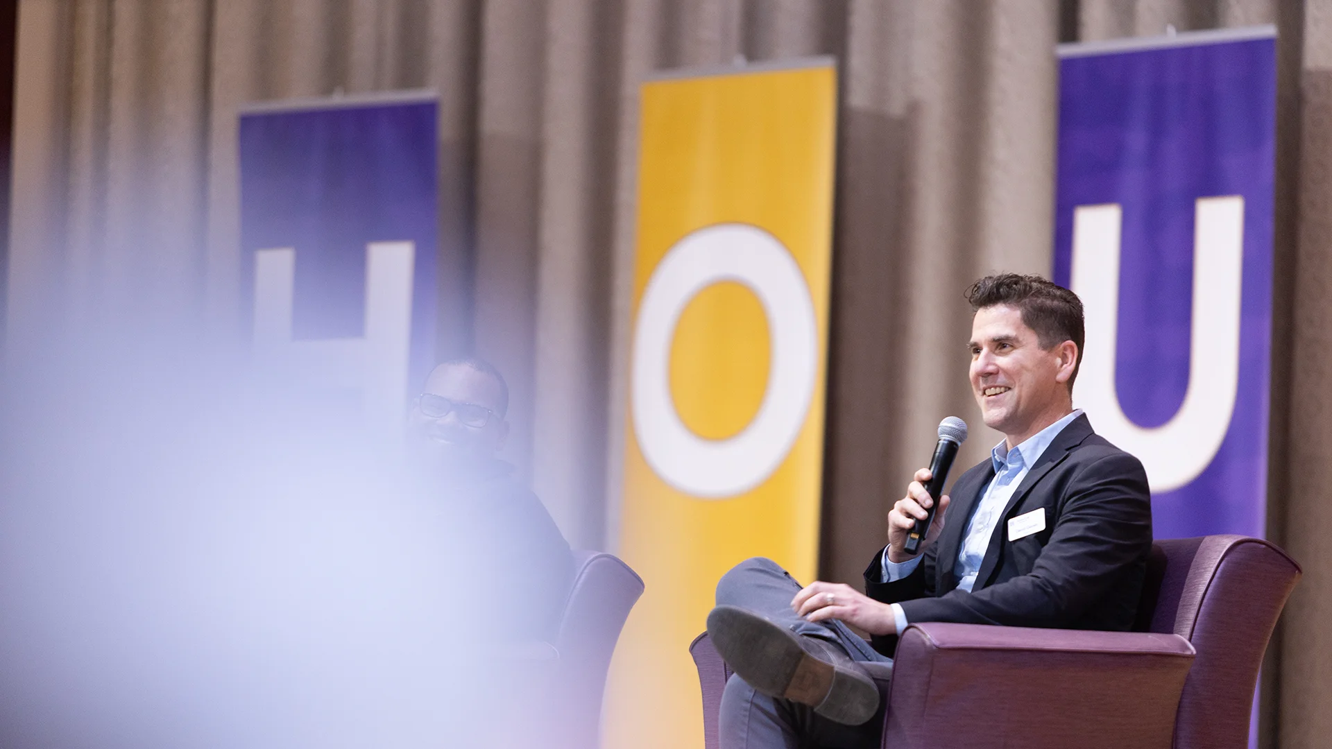 Houghton provost David Davies sitting on stage speaking during Accepted Student Day.