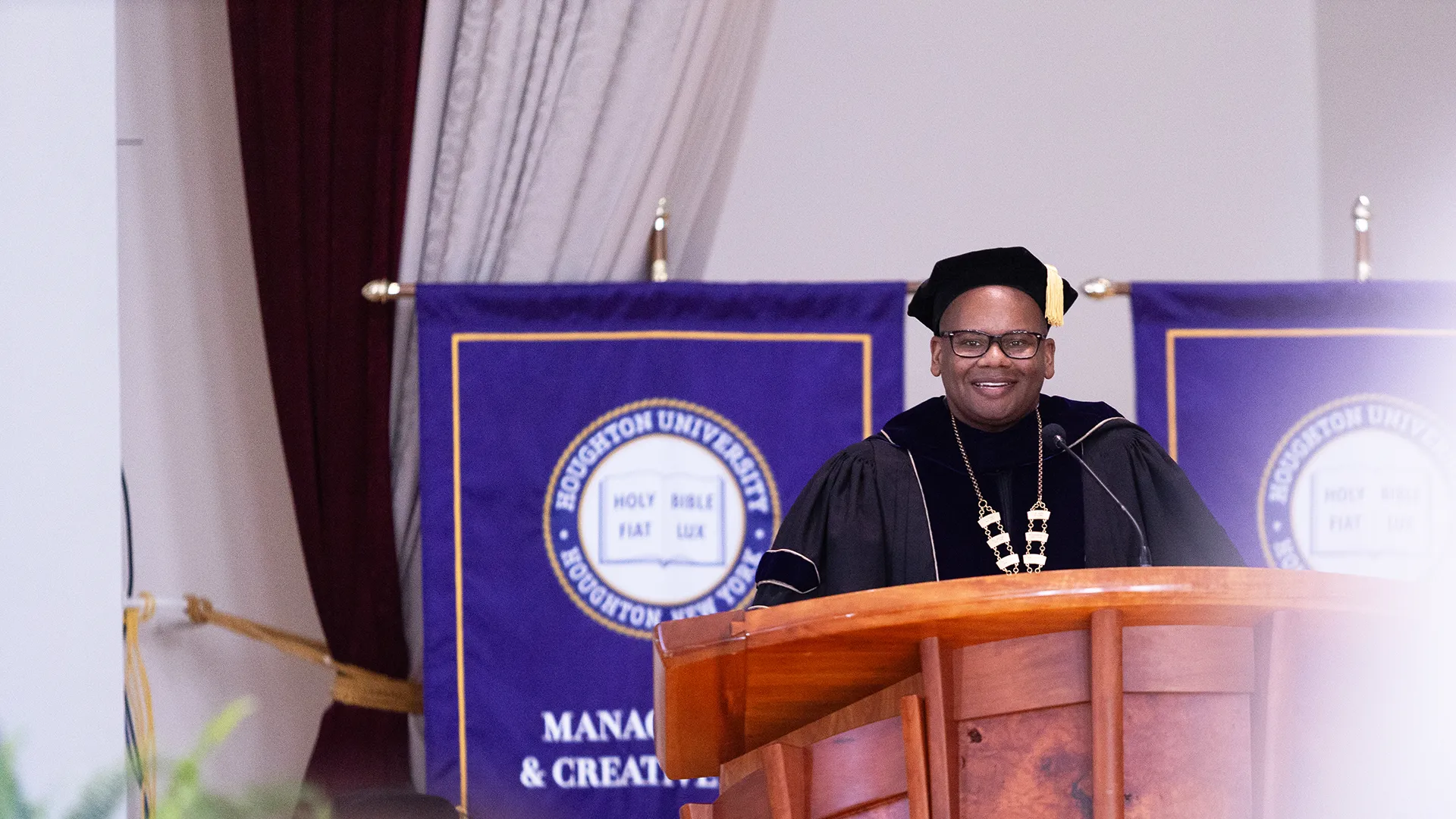 Houghton President Wayne Lewis standing at podium during commencement.