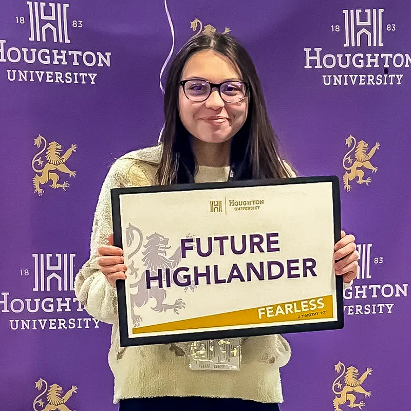 Incoming Houghton student Bailey Lewis holding sign that reads Future Highlander.