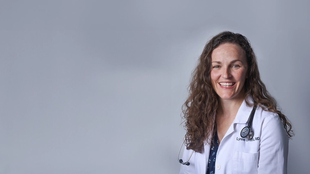 Houghton alumna Lynne Orozco in lab coat with stethoscope.