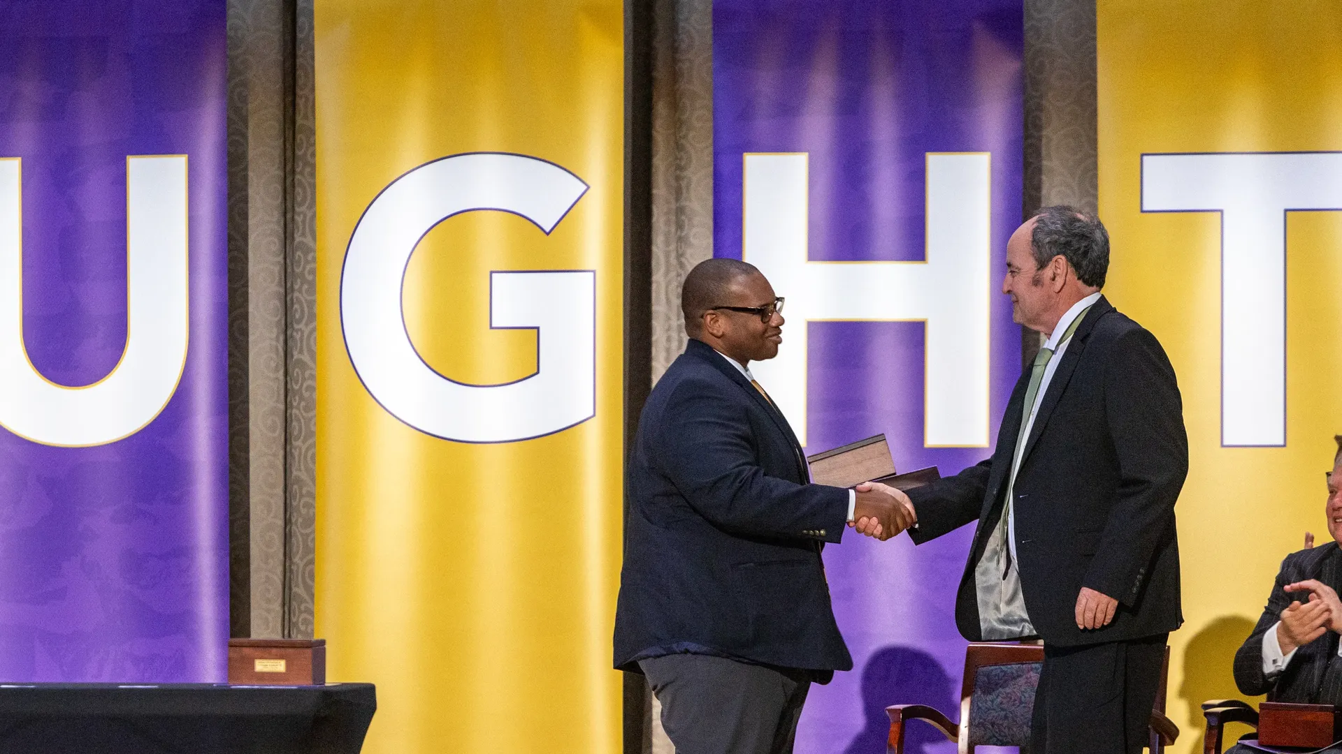 Alumnus Dr. James Rogan accepting alumni award from university president Dr. Wayne Lewis.