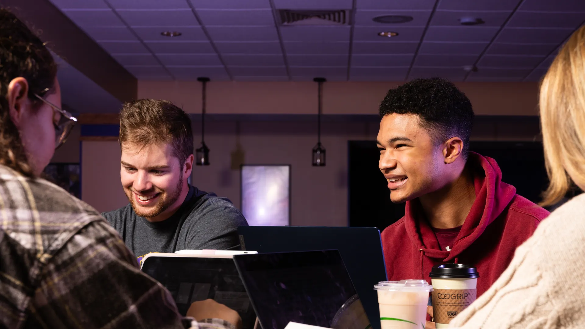 Houghton student sitting in lounge together with laptops and coffee.