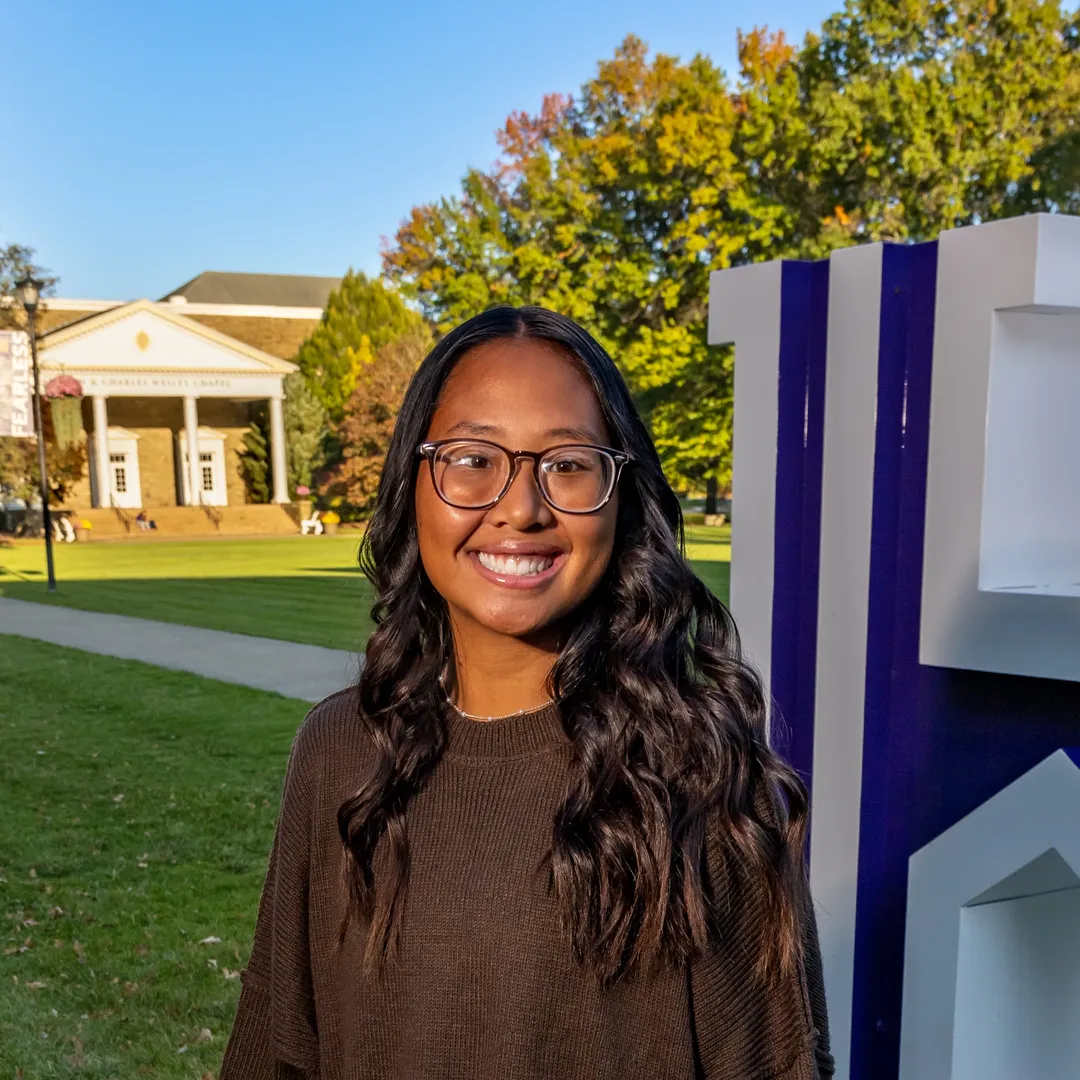 Houghton student MyaKay Bartman standing on by H on quad during beautiful fall day.