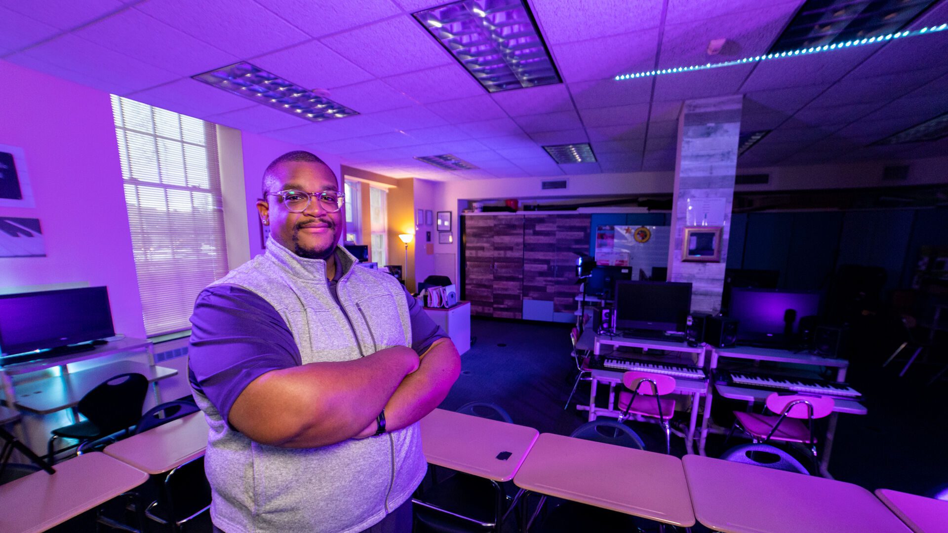 Alumnus Jerbrel Bowens stands in a classroom looking at the camera