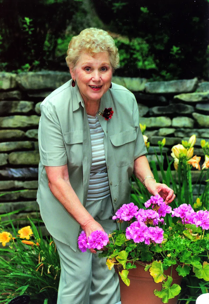 Joyce Chamberlain tending to outdoor flowers.