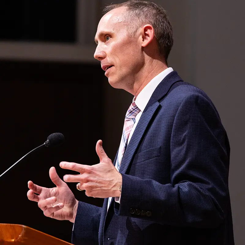 Houghton University JL Miller speaking on the stage of the Chapel.