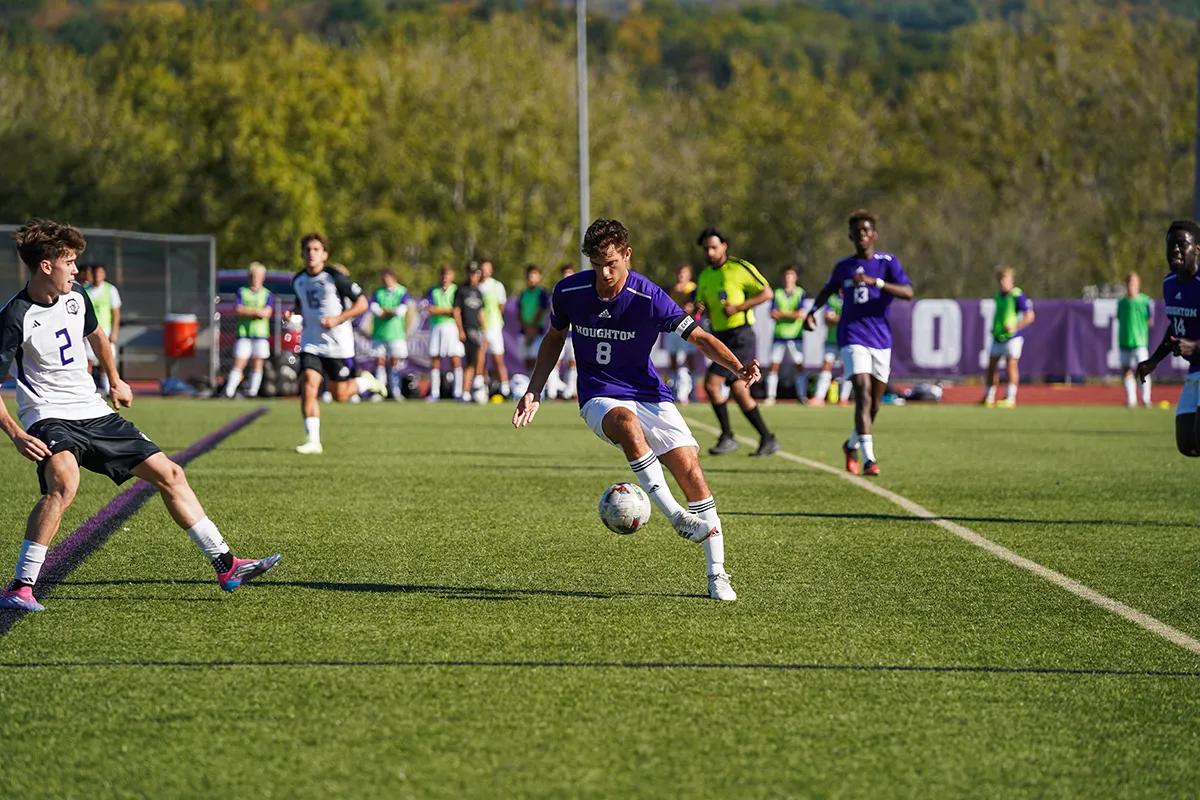 Houghton University soccer team playing on field.