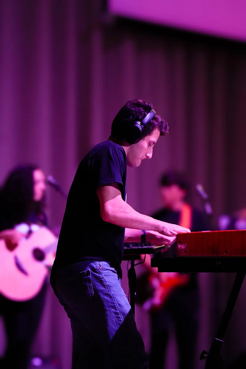 Houghton student standing and playing piano at SPOT.