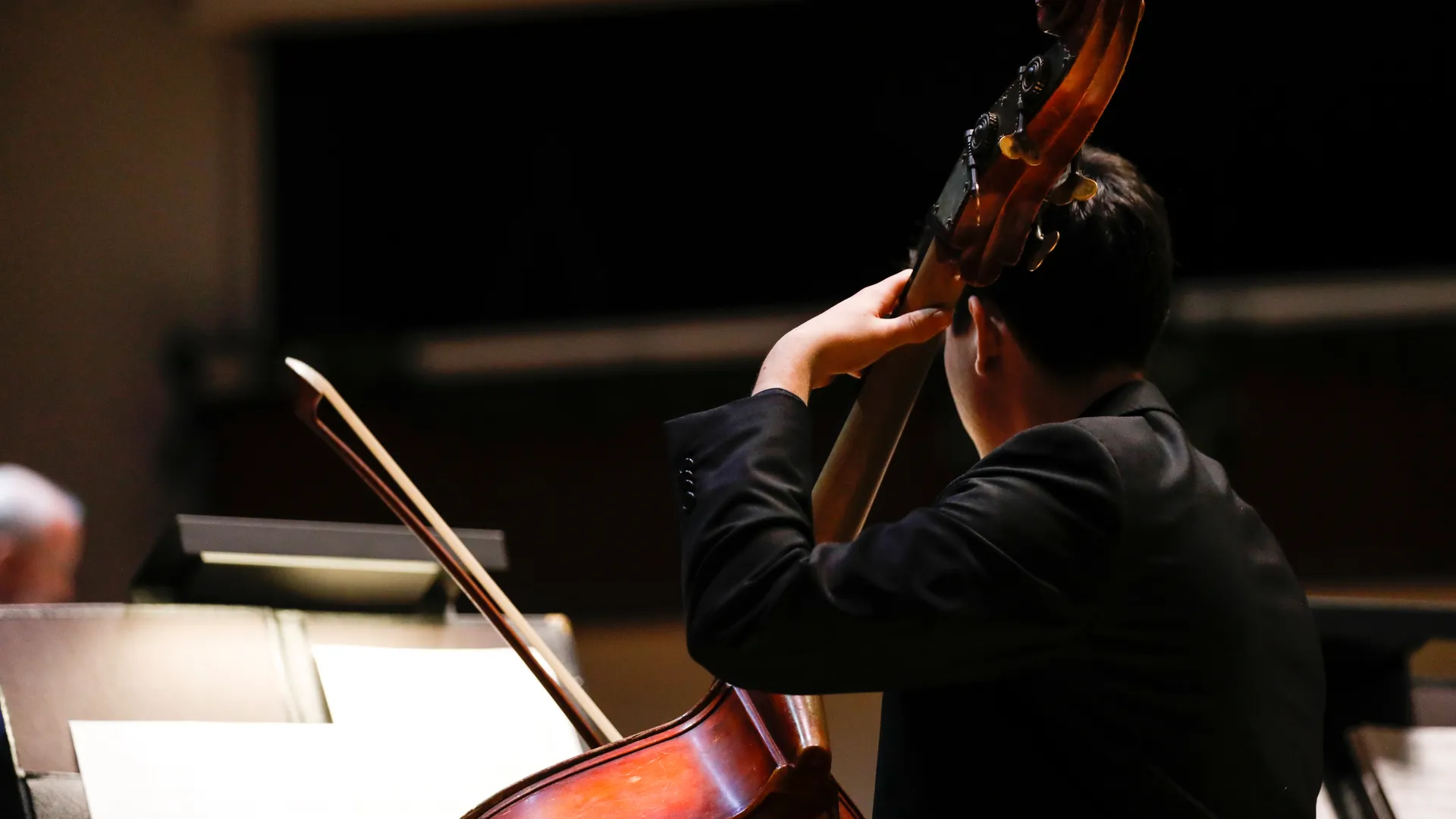 Houghton music student playing cello on stage.