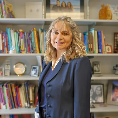 Michele Vanasee standing by a book shelf